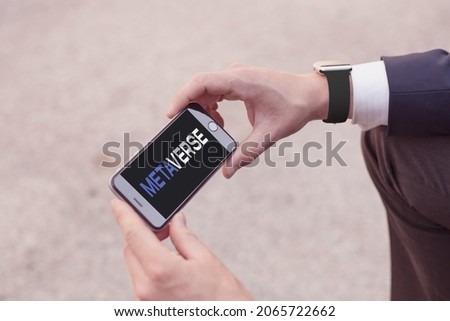 FACEBOOK META Metaverse concept. Businessman using Smartphone silhouette with METAVERSE word on blurred background. 