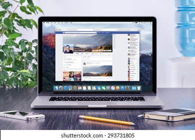 Facebook Timeline in user profile on the Apple Macbook Pro Retina screen that is on office wooden desk. Facebook is the most popular social network in the world. Varna, Bulgaria - May 31, 2015.