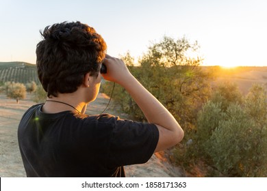 Faceless Boy Using Binoculars In The Countryside For Birdwatching.