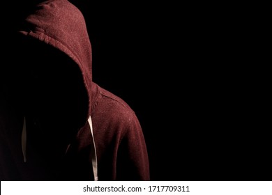 Faceless man in a hoody in dark shadows to disguise face - Powered by Shutterstock