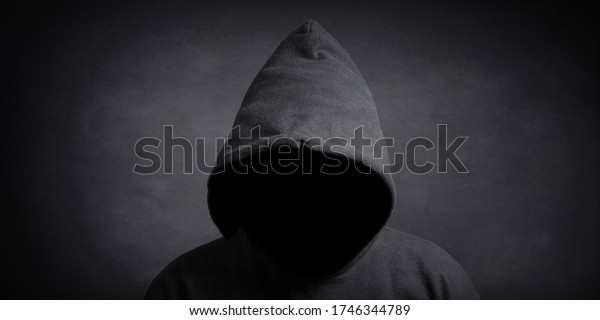 faceless person wearing black hoodie\
hiding face in shadow - mystery crime conspiracy\
concept