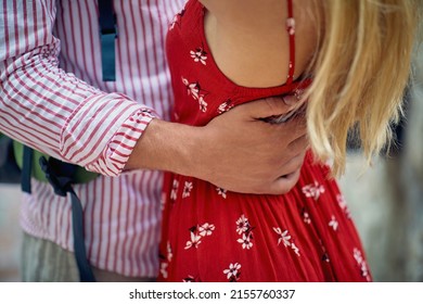 Faceless shot of couple hugging. Man hugging woman in beautiful red dress around her waist. Love, holiday, lifestyle concept.