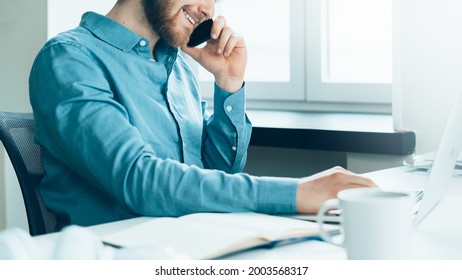 Faceless Smiling Busy Man Entrepreneur In Casual Clothes Talking On Mobile Phone And Looking At Laptop Computer Screen With Smile While Working In Modern Office, Male Office Worker Call To Client