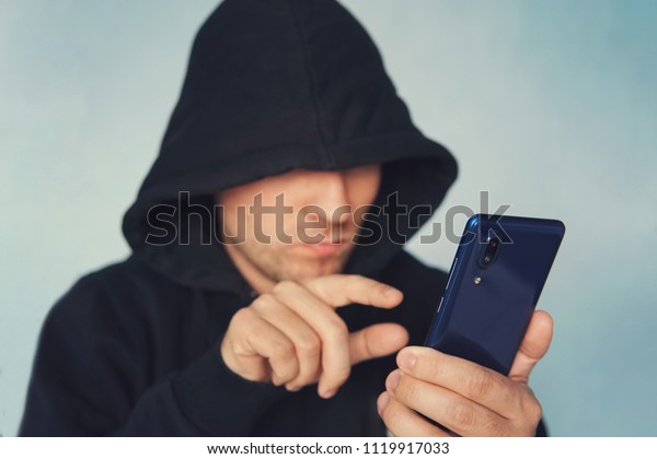 Faceless Unrecognizable Hooded Person Using Mobile Phone Identity