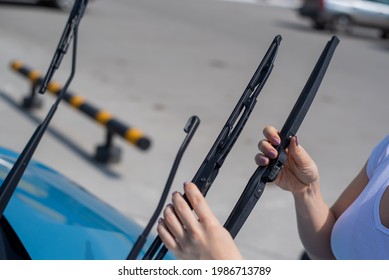 Faceless Woman Changing Car Windshield Wipers.