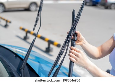 Faceless Woman Changing Car Windshield Wipers.