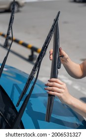 Faceless Woman Changing Car Windshield Wipers.