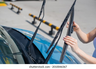 Faceless Woman Changing Car Windshield Wipers.