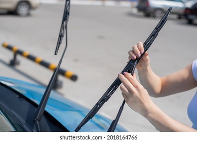 Faceless Woman Changing Car Windshield Wipers.