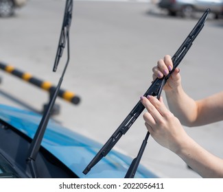 Faceless Woman Changing Car Windshield Wipers.