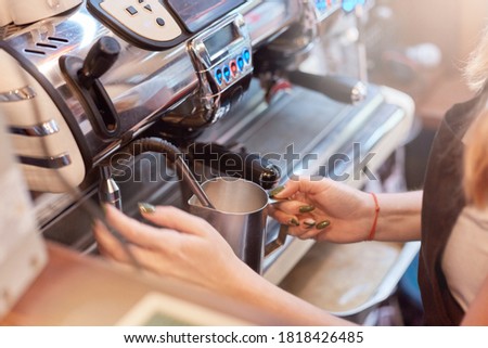 Faceless woman holding turk, barista making coffee, unknown waitress working in coffee shop, device for making hot beverage, process of making espresso.