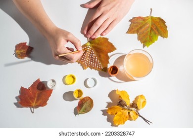 Faceless Woman Paints Fall Leaves On A White Background. Creativity And Zero Waste. Top View 