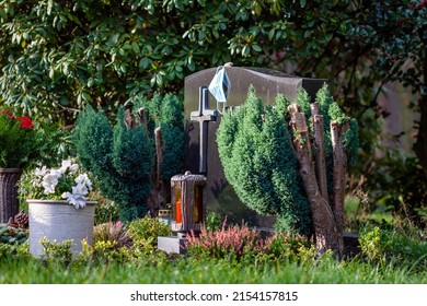 Facemask Lying On Grave Of Family Members With A Facemask During The Pandemic