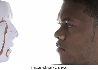 Face-off - young black man contemplates blood-stained mask - Shutterstock ID 27176926