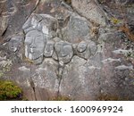 Faces chiseled into rock Qatortoq, Greenland.