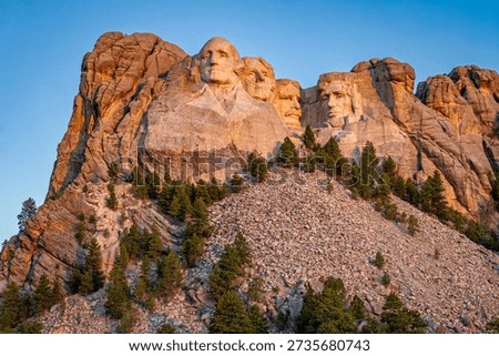 The faces of Mount Rushmore in the warm glow of the sunrise, South Dakota