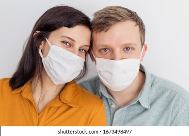 Faces of people in protective masks from coronavirus hand made. A beautiful blue-eyed quarantined couple protecting themselves from a pandemic. Positive young youth. Lifestyle COVID-19 home together - Powered by Shutterstock