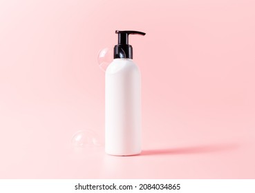 Facial cleaner bottle with soapy bubbles. White with black pump Beauty skincare cosmetic packaging mockup