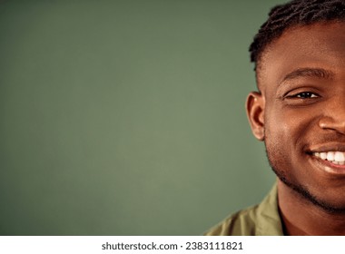 Facial expression. Half face of smiling african american man posing over green studio background with copy space. Close up of carefree good looking young guy with toothy laugh indoors. - Powered by Shutterstock