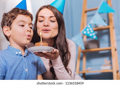 Facial expressions. Concentrated boy looking at fancy cake while making wish