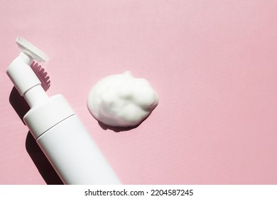 Facial Foam Dispenser And Face Foam Texture On Pink Background