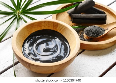 Facial mask and scrub by activated charcoal powder on wooden table