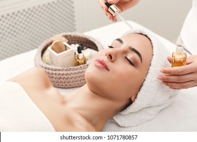 Facial Massage. Spa, Resort, Beauty And Health Concept. Beautiful Woman Getting Professional Face Treatment With Nourishing Organic Oil, Copy Space