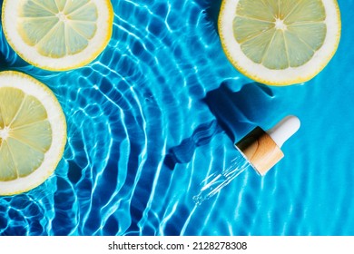 Facial Pipette Serum, Whey Beauty Product Near Fruit Citrus Lemon In Water Splashing Fresh Transparent, Flecks. Flat Lay, Top View. Summer Beach Tropical. Organic Skin Body Antiage Care In Hot Climate