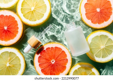 Facial Pipette Serum, Whey Beauty Product Near Fruit Citrus Lemon And Grapefruit In Water Fresh Transparent. Flat Lay, Top View. Summer Beach Tropical. Organic Skin Body Antiage Care In Hot Climate