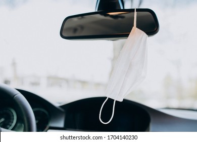 Facial Protection Mask Hanging On The Mirror In Car