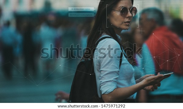 Facial recognition and search and surveillance\
of a person in the modern digital age, the concept. Young woman\
with phone in crowd of people on the street, identification and\
modern technology