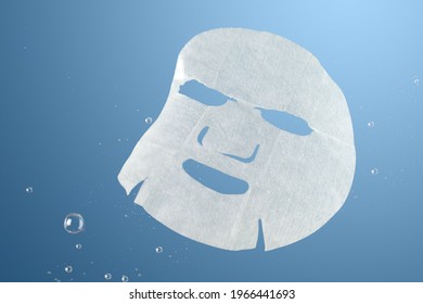 A Facial Sheet Mask Under Water On Blue Background. Skin Care Concept.