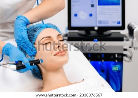Facial skin care machine in spa clinic for anti-aging or acne treatment. The concept of aesthetic medicine, beauty tools, latest technologies in beauty industry.