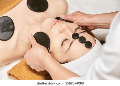 Facial Stone Massage. Hot Face Masseur. Girl At Salon With Doctor Hands.