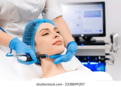 Facial treatment. Nice young woman lying on the medical bed while having a beauty procedure - Powered by Shutterstock