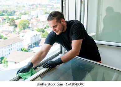 A Facility Management Cleaner Cleaning A Window And Window Frame With Green Micro Fiber Cloths