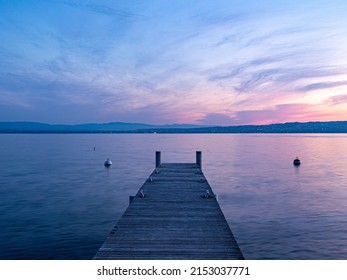 Facing lake of Geneva , from a wooden pontoon at dawn 