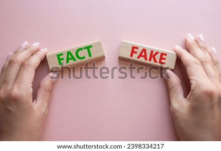 Fact or Fake symbol. Concept word Fact or Fake on wooden blocks. Businessman hand. Beautiful pink background. Business and Fact or Fake concept. Copy space