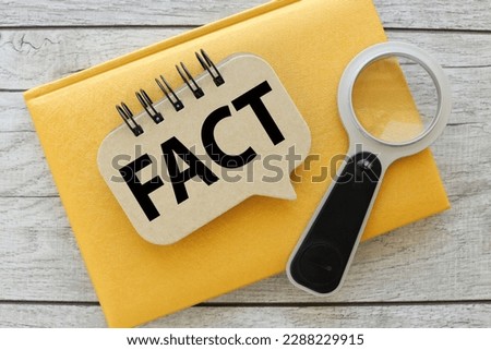 Fact - notepad with spring on yellow notepad. cover text
