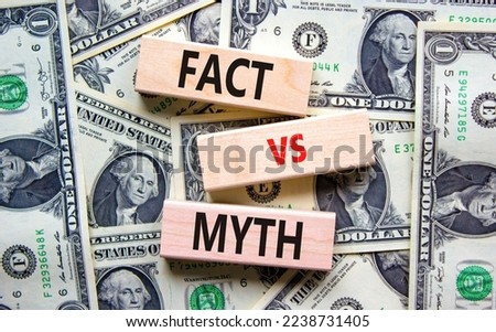 Fact vs myth symbol. Concept words Fact vs myth on wooden blocks on a beautiful background from dollar bills. Business, finacial and fact vs myth concept. Copy space.