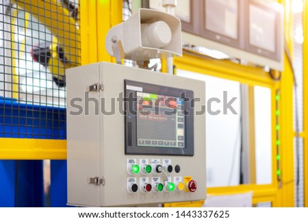 Factory 4.0 concept : View of operation panel and product inspection monitoring display on fence of manufacturing machine.
