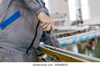 Factory for aluminum and PVC windows and doors production. Manual worker assembling PVC doors and windows. Selective focus. - Shutterstock ID 499348570