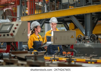 Factory apprenticeship. Man mentor teaching Female employees trainee operating machine looking monitors and check Production process machinery. foreman explaining woman engineer control machine - Powered by Shutterstock