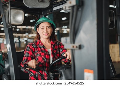 At the factory an Asian woman engineer skillfully drives a forklift truck indoors portraying an adult female professional in an industrial setting managing tasks within the warehouse - Powered by Shutterstock