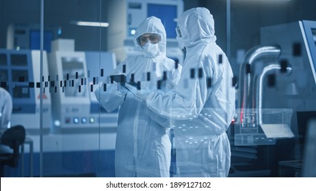 Factory Cleanroom: Engineer and Scientist Wearing Coveralls, Standing in Workshop Talk and Use Tablet Computer, Professionals Develop Technology for Modern CNC Machinery and Electronic Equipment
