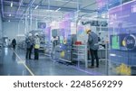 Factory Digitalization: Two Industrial Engineers Use Tablet Computer, Big Data Statistics Visualization, Optimization of High-Tech Electronics Facility. Industry 4.0 Machinery Manufacturing Products