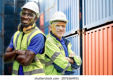 Factory engineer African worker man standing confidence with green working suite dress and safety helmet n front of container and cargo space. Business people working in shipping transport industry.