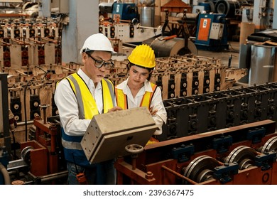 Factory engineer manager with assistant conduct inspection of industrial steel forming machine, exemplifying leadership as metalwork machinery engineering inspection supervisor in the facility. - Shutterstock ID 2396367475