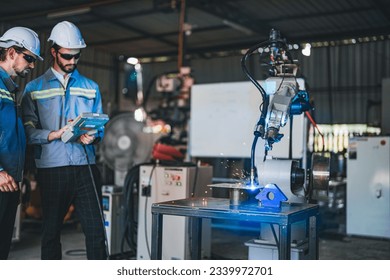 factory engineers using smart control to control the arm robot machine for cutting the metal sheet. specialist Worker working at height technology industry for produce the electronic part device.