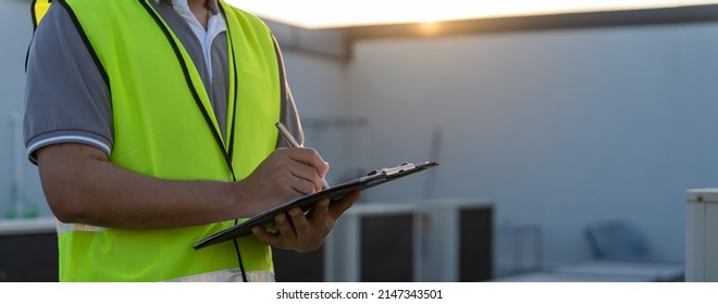 Factory engineers walking and checking the cooling system of the factory. Fore man records the condition of the compressor before maintenance according maintenance plan. - Shutterstock ID 2147343501